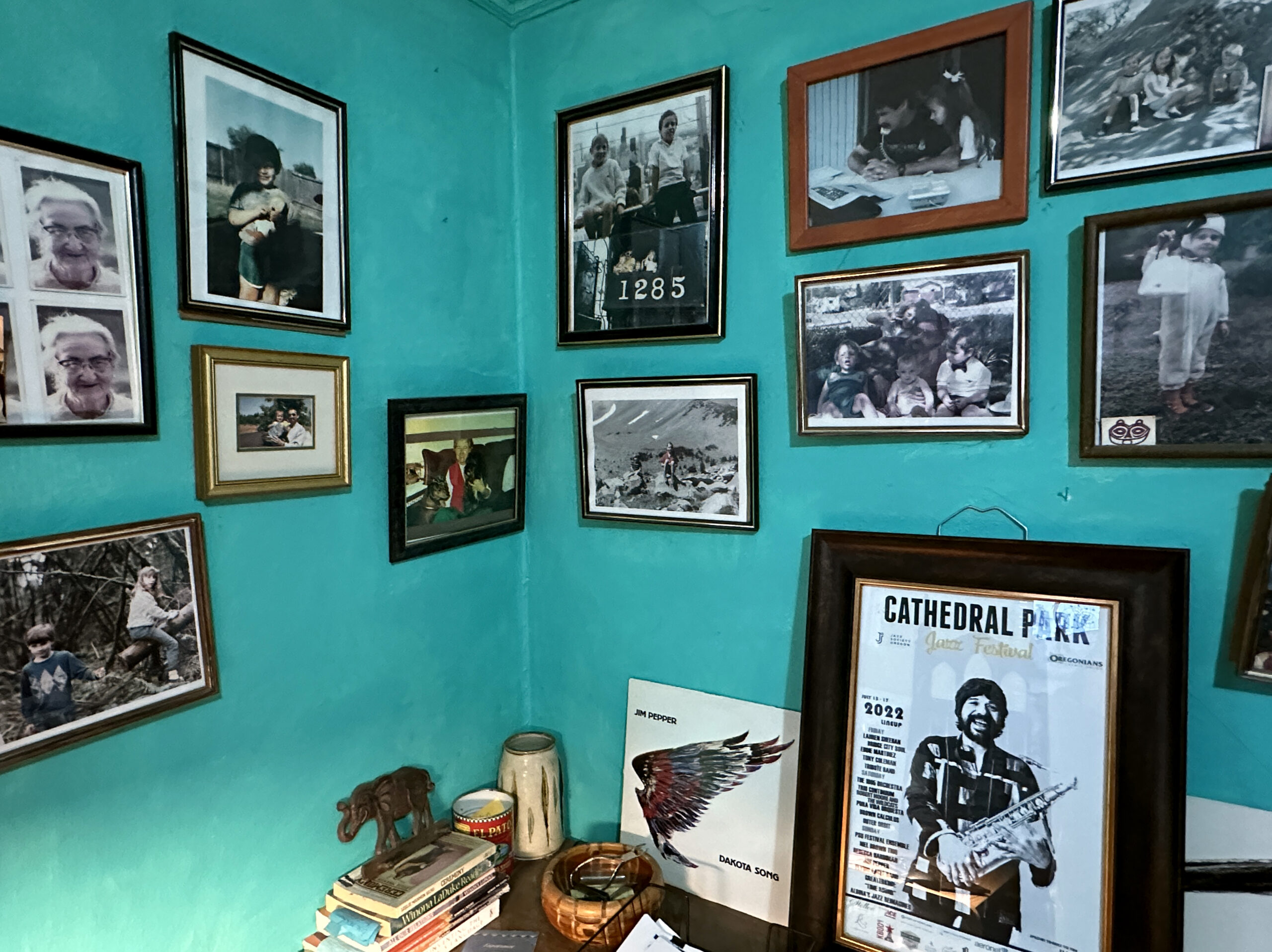Sean Cruz’s family photos and Jim Pepper posters and memorabilia cover the walls and surfaces in Sean Cruz’s home. The walls are turquoise colored.